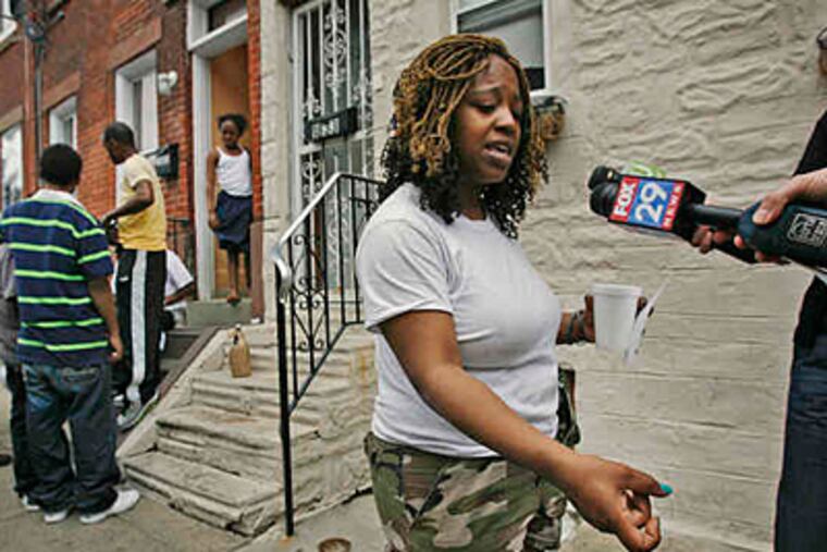 File photo: Shanae Williams demonstrates the way she says her estranged husband held a gun as he shot her brother, while children and adults were having a water fight in the 1800 block of Hoffman Street. (05/04/2010; Alejandro A. Alvarez/Staff)