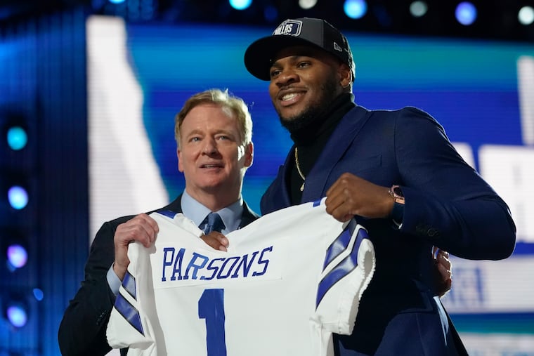 Penn State linebacker Micah Parsons (right) held a Cowboys jersey with NFL commissioner Roger Goodell after being chosen with the 12th pick Thursday night.