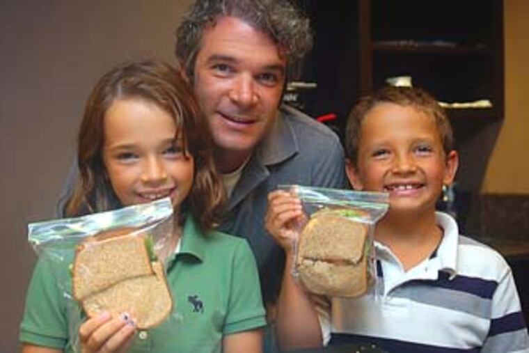 Kali, 10, Drew (dad) and Jacob Masciangelo, 8, pose with their newly made lunch sandwiches. They made cucumber, tomato and lettuce sandwiches on wheat bread; their lunch included lemonade juice boxes and oranges. August 27, 2009 (Sarah J. Glover / Staff Photographer) EDITOR'S NOTE: G2FOOD03A Story on kids helping to make lunches.