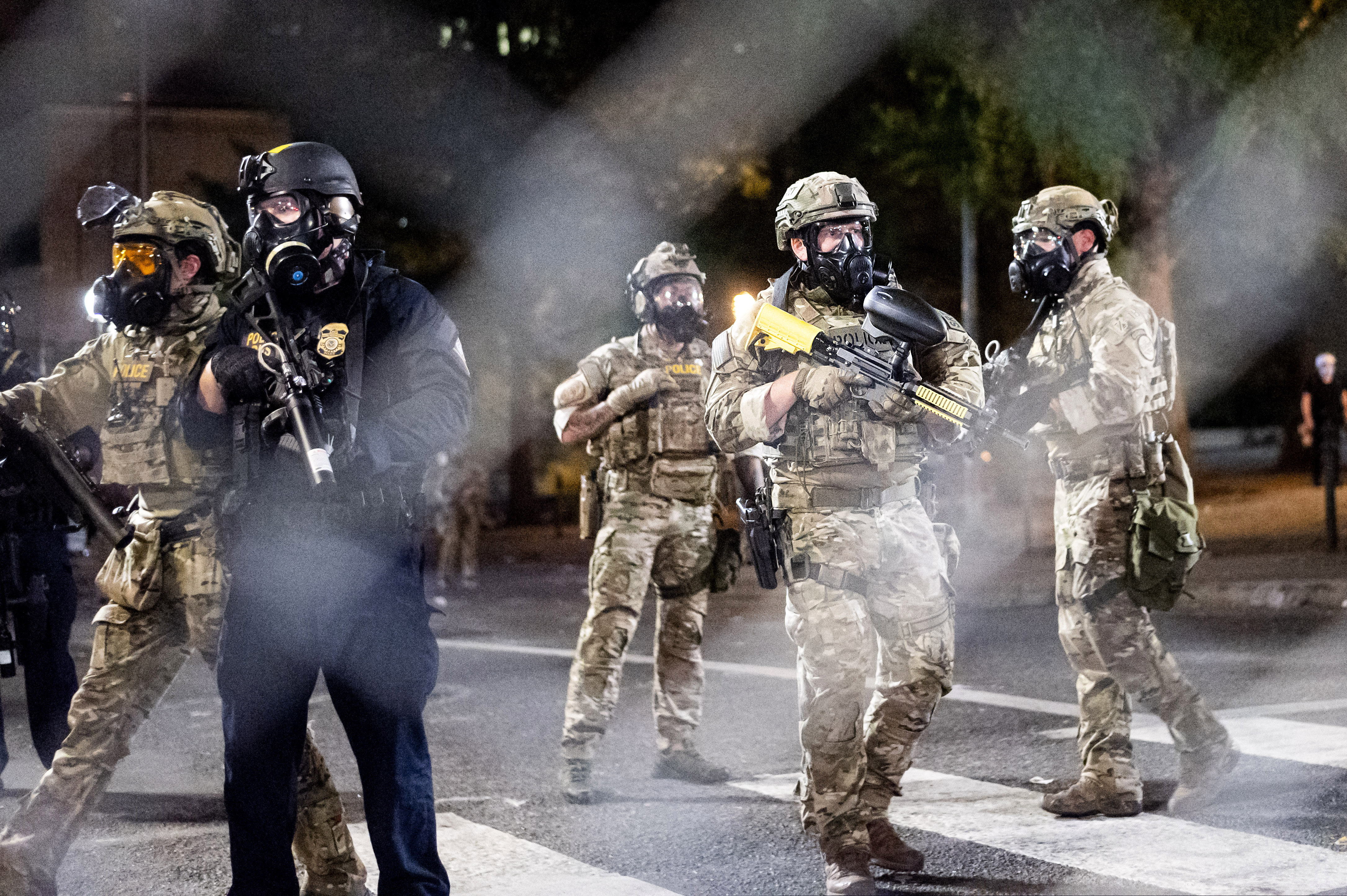 Federal agents dispersing Black Lives Matter protesters near the Mark O. Hatfield United States Courthouse in Portland, Ore., on Monday. Officers used tear gas and projectiles to move the crowd after some protesters tore down a fence fronting the courthouse.