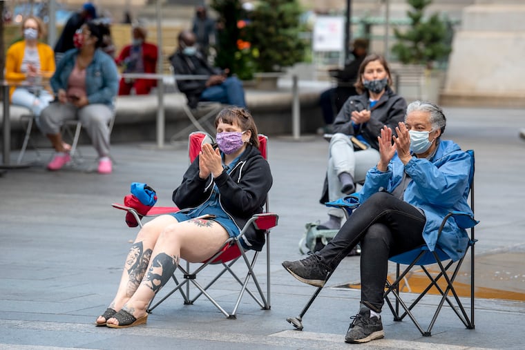 The audience applauds a percussion trio from The Philadelphia Orchestra as they are the first to perform this season, at Dilworth Park at City Hall on May 5.