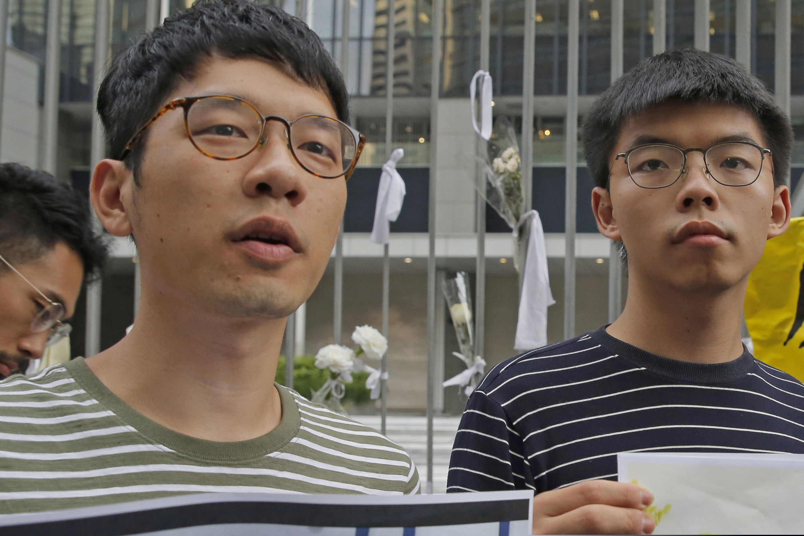 Pro-democracy activists Nathan Law (left) and Joshua Wong speak to the media outside the government office in Hong Kong in June 2019.