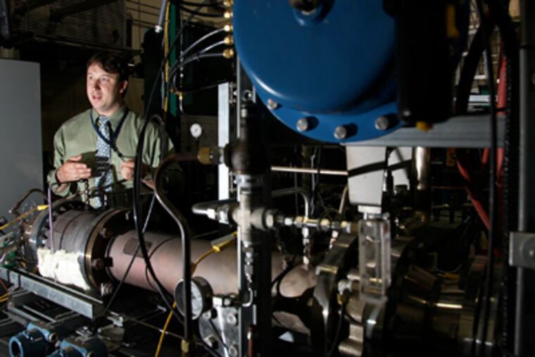 Engineer John Heinzel demonstrates new fuel cell technology being developed at the Naval Ship Systems Engineering Station in South Philadelphia at the site of the former Navy Yard. Below, electric motors installed on a test facility that is being developed for the U.S. Navy. (Laurence Kesterson / Staff Photographer)