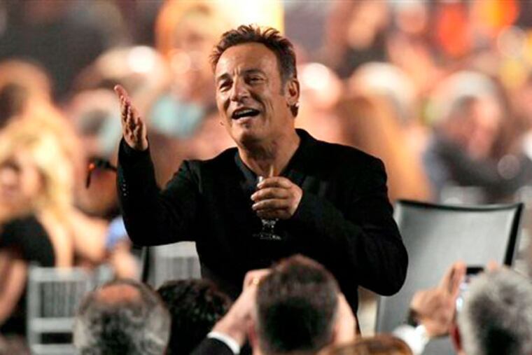 Honoree Bruce Springsteen gestures to attendees at the MusiCares Person of the Year tribute at the Los Angeles Convention Center on Friday Feb. 8, 2013, in Los Angeles. (Photo by Chris Pizzello/Invision/AP)