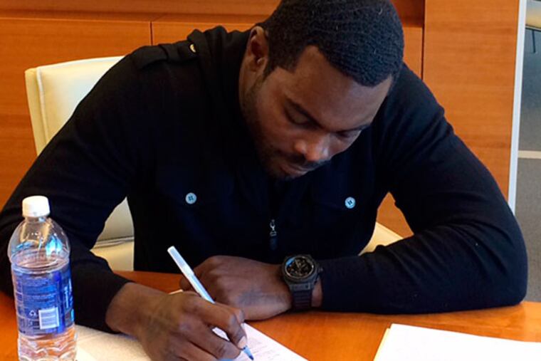 In this image released by the New York Jets, NFL football free-agent quarterback Michael Vick signs with the New York Jets Friday, March 21, 2014, in Florham Park, N.J. The Jets signed the former Philadelphia Eagles quarterback to a one-year deal on Friday, and released Mark Sanchez, the one-time face of the franchise. (AP Photo/New York Jets, @nyjets)