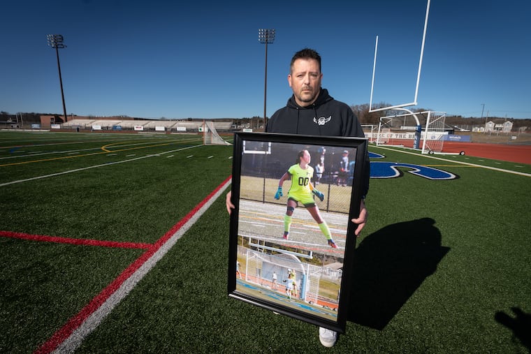 Mike Herman shown here in early February with a photograph of his daughter Schyler, at her high school on the field where she played soccer, at Pleasant Valley High School, in Brodheadsville, Pa.
