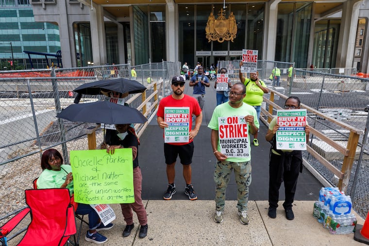 Members of Philadelphia municipal workers union AFSCME District Council 33 on Tuesday stand outside the Municipal Services Building across from City Hall.