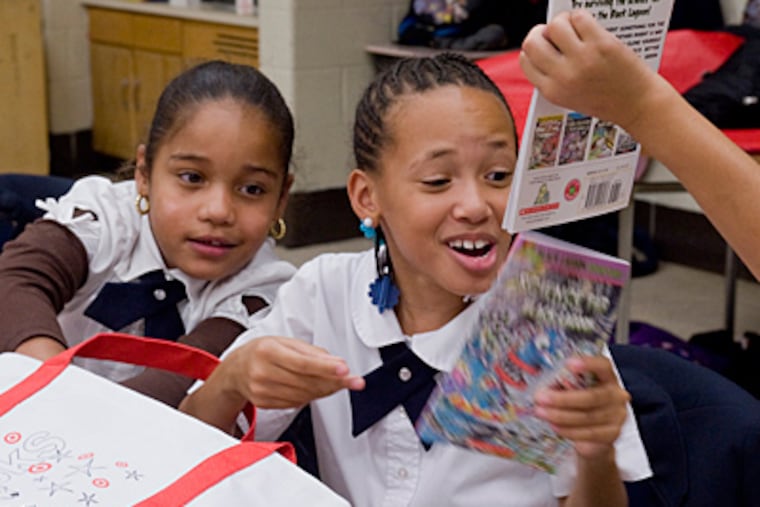 Francheska Bermudez (left) and Lamaje Moss, received free books to take home. (Clem Murray/Staff)