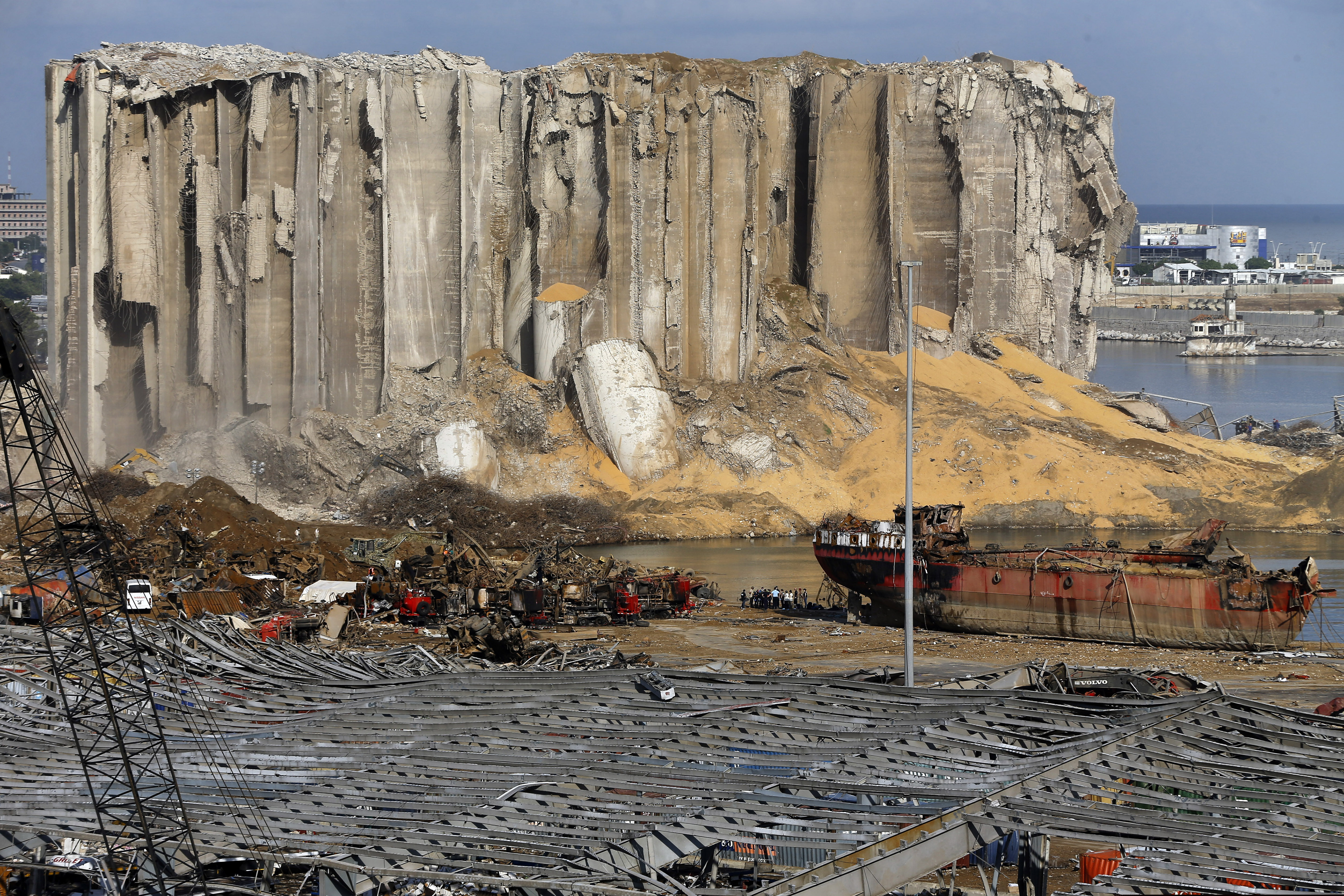 Earth moving equipment and rescue workers search for victim in Beirut, Lebanon, near the site of last week's explosion that hit the city's seaport.