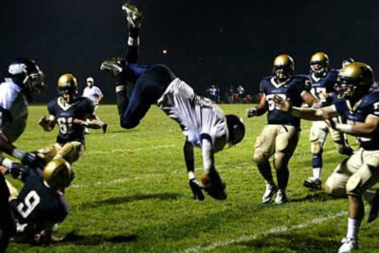 W. Catholic's Brandon Hollomon flies over a host of would be LaSalle's tacklers. (Ron Cortes / Staff Photographer)