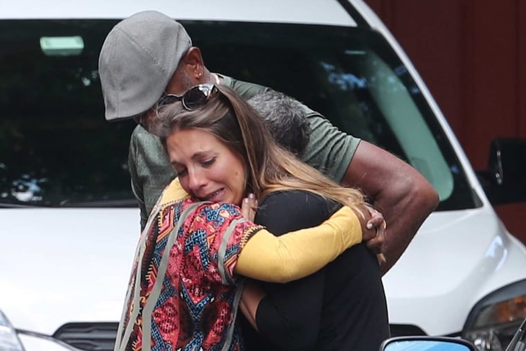 Kristin Grandzol, wife of Spring Garden community activist Gerard Grandzol ,who was fatally shot in the head in his car Thursday night, is comforted by neighbors and friends.