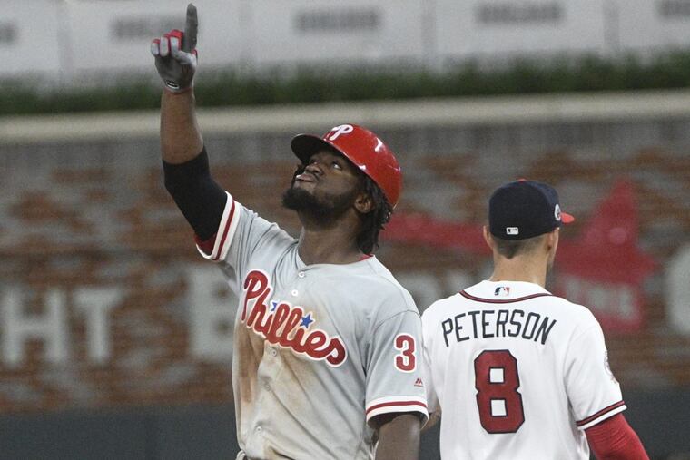 Odubel Herrera motions skyward at second base next to Atlanta Braves second baseman Jace Peterson after hitting a line drive double to right field, during the ninth inning Tuesday night.