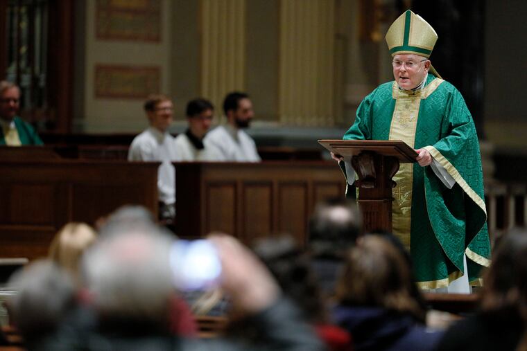 A parishoner (left) takes a photo as Archbishop Charles J. Chaput officiates his final Sunday Mass at the Cathedral Basilica SS. Peter & Paul in Philadelphia.