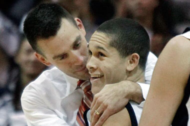 Council Rock North coach Derek Wright hugs Aaron Morgan after he scored the 1000th point of his career. (Elizabeth Robertson/Staff Photographer)