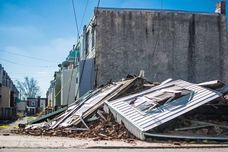 A house on the 1400 block of S. Patton St. in Grays Ferry collapsed early Saturday morning, Feb. 27, 2016. A man was taken to Penn Presbyterian Medical Center. ( AARON WINDHORST / Staff Photographer )