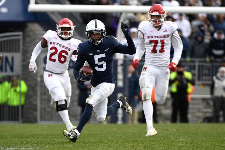 Penn State wide receiver Jahan Dotson (5) breaks away from Rutgers defenders CJ Onyechi (26) and Aaron Lewis (71) during an NCAA college football game in State College, Pa., Saturday, Nov. 20, 2021. Penn State shut out Rutgers 28-0. (AP Photo/Barry Reeger)