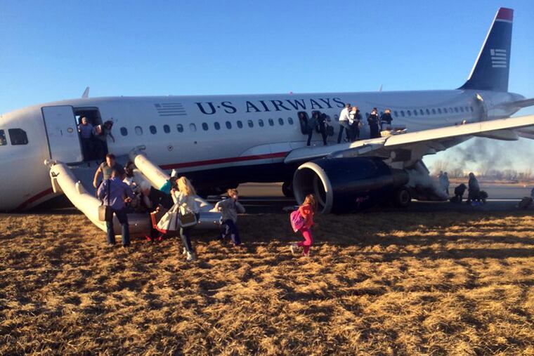 Passengers evacuate the US Airways plane on March 13, 2014, at Philadelphia International Airport.