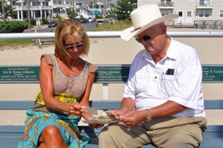 Ann Richardson and her father, Edward Johnson, look over photos of the historic Ocean City ice-cream shop that was destroyed in a mysterious fire on Sept. 2, 1969. (Gail Crafton / For the Daily News)