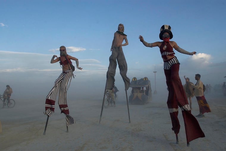 Stilt walkers enjoy a sunset stroll at the 2004 Burning Man counter culture arts festival.