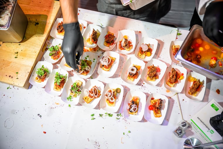 A chef puts the finishing touches on food at the first Inquirer Food Festival at the Fillmore in 2025.