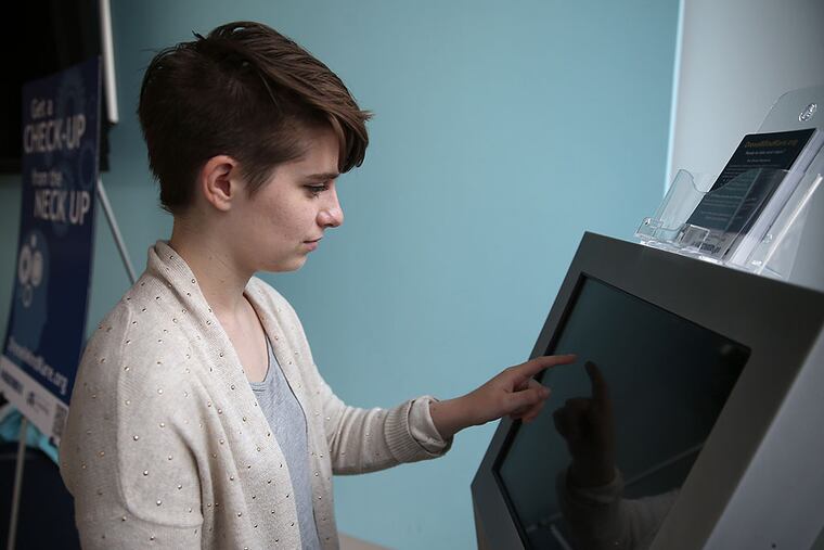Anna Gibbons, a sophomore, demonstrates the mental-health kiosk at Drexel University's rec center. "Just the fact that it's there is already helping to reduce the stigma," she says. DAVID MAIALETTI / Staff Photographer