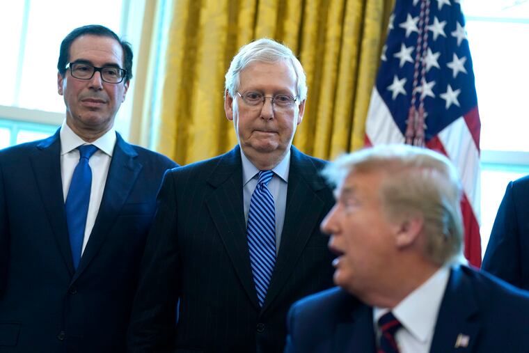 Treasury Secretary Steven Mnuchin (left) and Senate Majority Leader Mitch McConnell (middle), R-Ky., listening as President Donald Trump speaks before he signs the coronavirus stimulus relief package in the Oval Office at the White House last Friday.