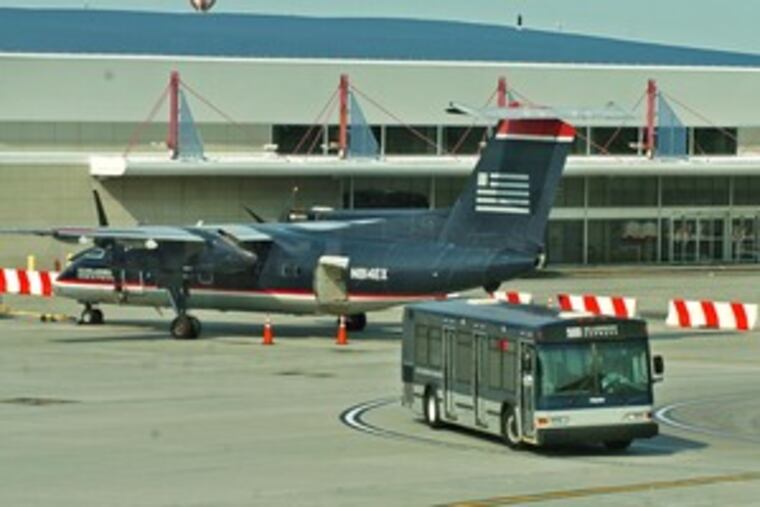 A US Airways bus leaves the outside gate area at Terminal F to ferry travelers to other terminals at the airport.