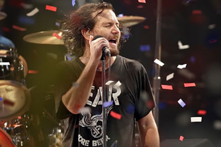 Eddie Vedder of Pearl Jam plays the last song as balloons and confetti fall in the Spectrum. (Laurence Kesterson / Staff Photographer)