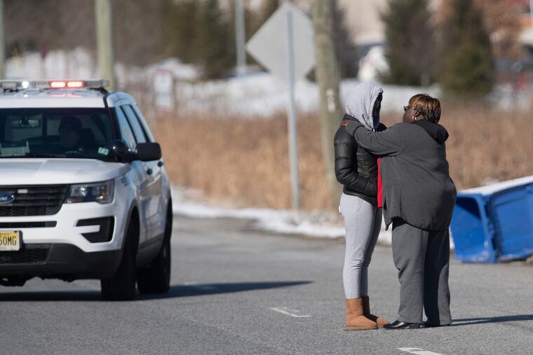 Two unidentified women were seen consoling each other at a police checkpoint on Jan. 14, 2019, after a report of an active-shooter situation that morning at a UPS facility in Logan Township, South Jersey.