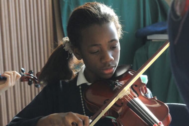 JMUSIC03P2 In Camden, N.J., children at Sacred Heart School learn violin. Here, Judith Okwamba plays. 1/31/12 APRIL SAUL / Staff Photographer