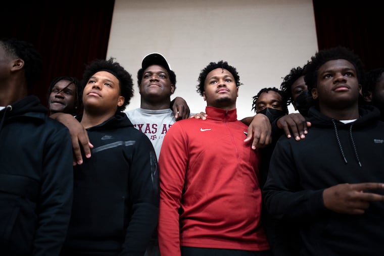 Northeast High seniors Naquil Betrand (center left) and Tyrese Whitaker pose after signing letters of intent to Texas A&M and Temple on Wednesday.