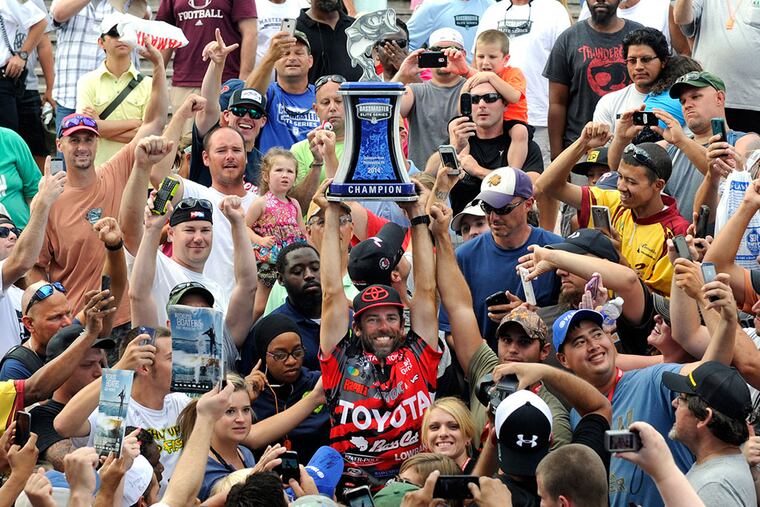 Mike Iaconelli of Pittsgrove, N.J., hoists the trophy he received for winning the Bassmaster Elite Series fishing competition on the Delaware River. TOM GRALISH / Staff Photographer