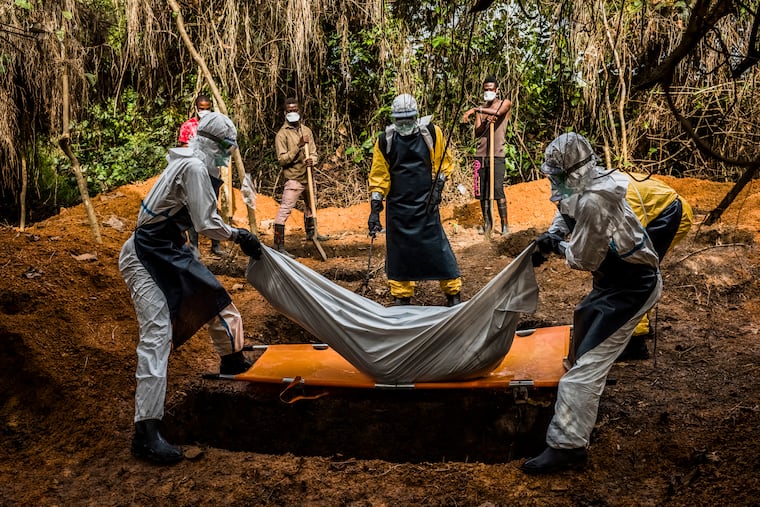 FILE — A team in Gbarnga, Liberia, buries a 37-year-old mother of three who died before she reached a center that could treat her during the Ebola outbreak of 2014, Oct. 5, 2014. An outbreak of the deadly Ebola virus in the Democratic Republic of Congo and Uganda has prompted the World Health Organization to declare a global health emergency.