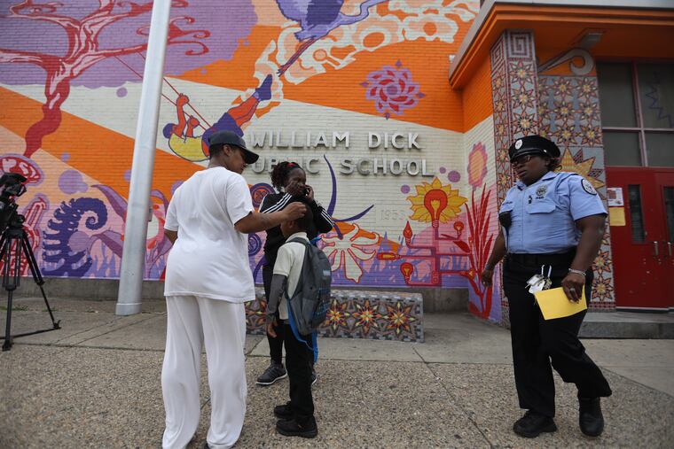 Parents wait for their children after a stabbing at the William Dick K-8 Public School on the 2400 block of Diamond Street in North Philadelphia on Friday.