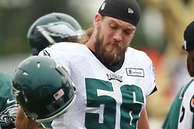 Eagles linebacker Bryan Braman, center, shakes the
dirt and grass out of his helmet before practice begins on Friday
during training camp. (Michael Bryant/Staff Photographer )