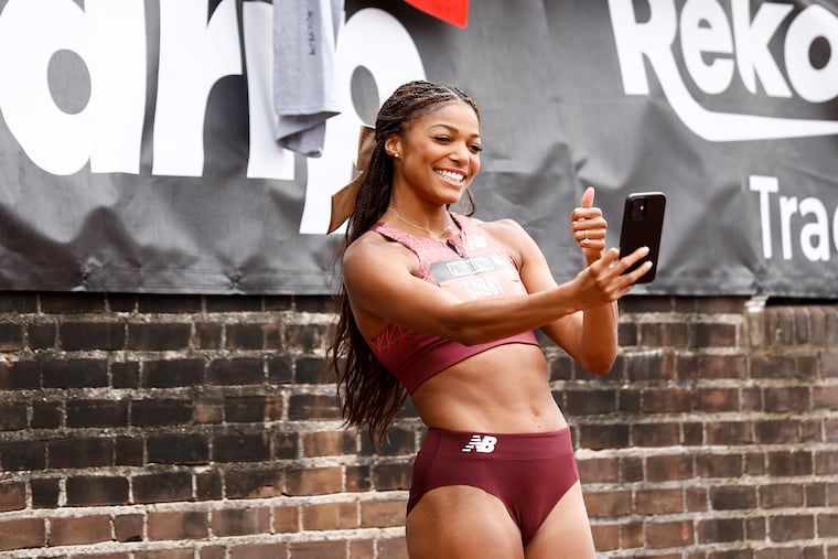 Gabby Thomas posed for selfies with fans (not pictured) after racing in the women's 100 meters during Grand Slam Track at Franklin Field on Sunday.