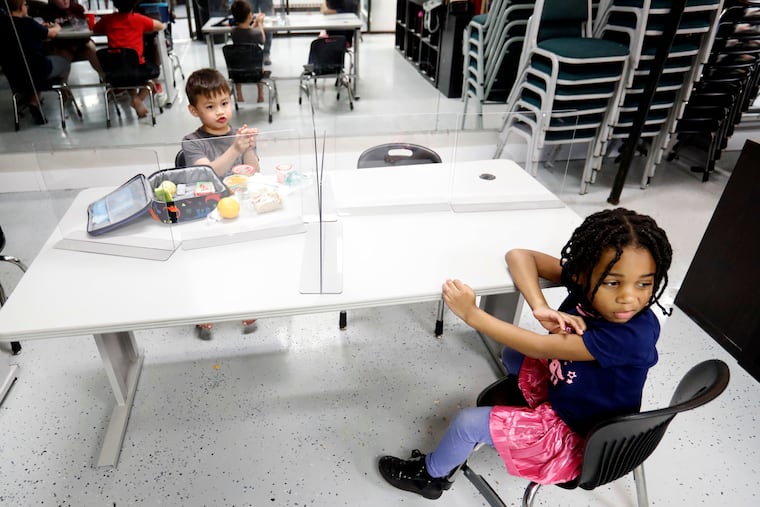 In-person summer camp won't happen for 3,000-plus children in Philadelphia because the Philadelphia School District has opted not to open its buildings to city providers, as it has for years. The district says the pandemic prevents it from making facilities available, a position advocates dispute. Here, children at a Texas camp are shown with plastic barriers separating them to stop the spread of the coronavirus.