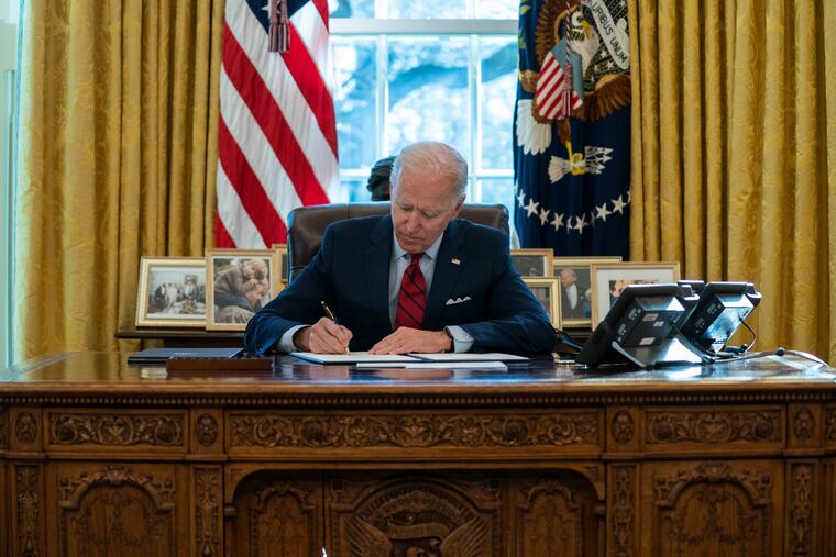 President Joe Biden signs a series of executive orders on health care, in the Oval Office of the White House, Thursday, Jan. 28, 2021, in Washington.