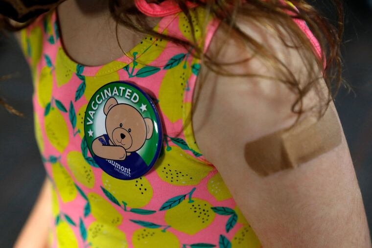 A child wore a pin she received after getting her first dose of the Pfizer COVID-19 vaccine at the Beaumont Health offices in Southfield, Mich., on Nov. 5, 2021.