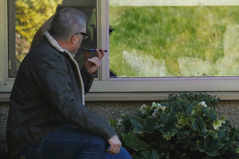 Marty Shape, left, talks to his mother, Judy Shape, right, on the phone as they look at each other through her window, Monday, March 9, 2020, at the Life Care Center in Kirkland, Wash., near Seattle. In-person visits at the facility are not allowed, as the nursing home is at the center of the outbreak of the coronavirus in Washington state.