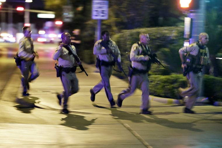 Police run to cover at the scene of the shooting near the Mandalay Bay Resort and Casino on the Las Vegas Strip.