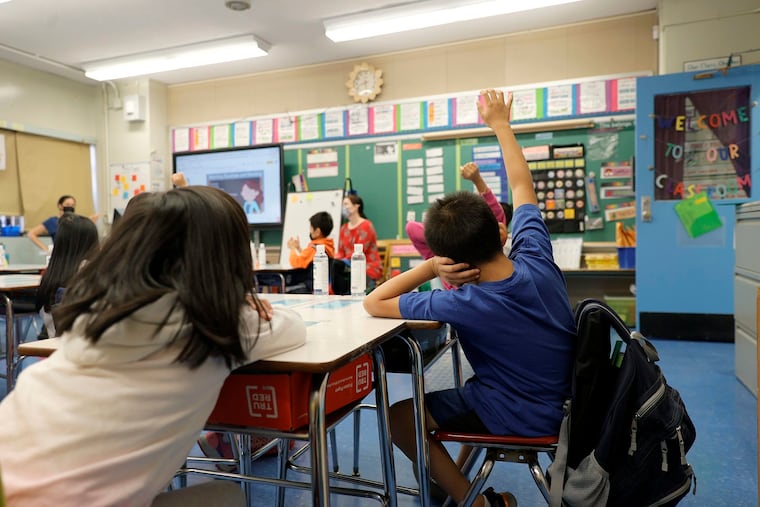Co-teachers at Yung Wing School P.S. 124 Marisa Wiezel (left) and Caitlin Kenny give a lesson to their masked students in their classroom in New York City.