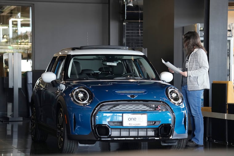 A potential buyer looks over a 2023 Cooper S sedan on the floor of a Mini dealership in mid-February in Highlands Ranch, Colo.