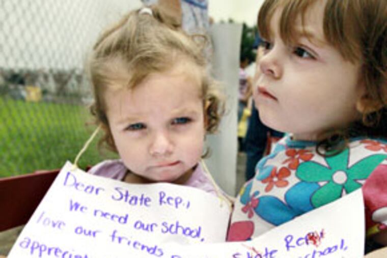 Madelyn Corkery, 1, left, and Emilee Davis, 2, of the Little Geniuses Academy with the signs they have been given to hold during the rally on Bustleton Avenue.