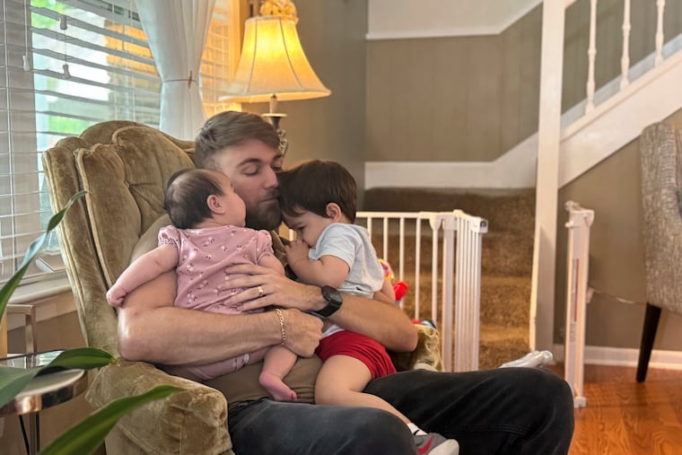 U.S. Marine Corps veteran Adrian Clouatre holds his three-month-old daughter Lyn and his nearly two-year-old son Noah at their home in Baton Rouge, La.