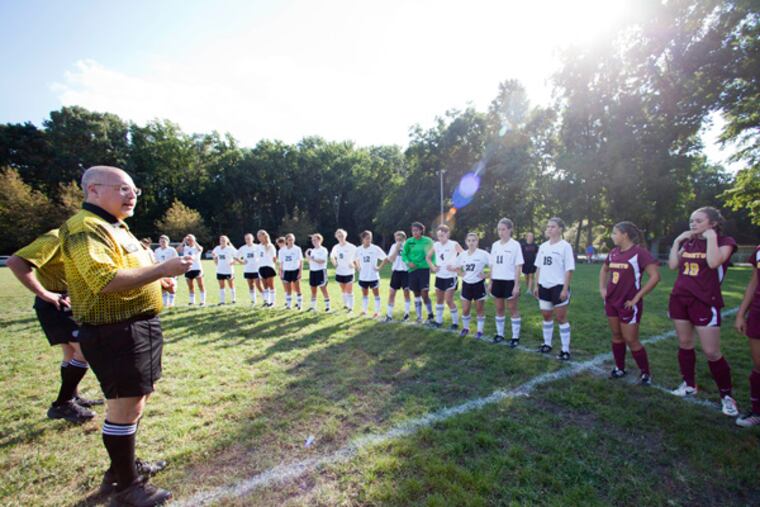 Pre-game photo of referee Jeff Simonetti reading new sportsmanship rules to the Haddon Heights and Haddonfield H.S. girls soccer teams before their match at the Devon Avenue Fields, Haddon Heights, September 20, 2013. (DAVID M WARREN / Staff Photographer)