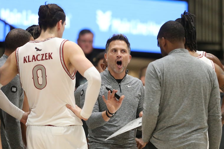 Coach Billy Lange of St. Joseph's huddles his team during the game against Villanova at Hagan Arena.