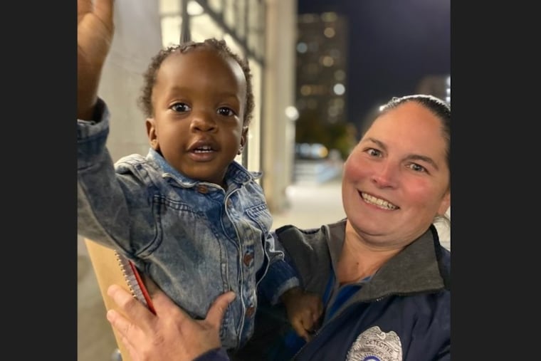 Hakeem Hintzen, who was taken from his mother on Saturday in Vineland, is held by an unnamed detective from the Cumberland County Prosecutor's Office outside of the headquarters of the Philadelphia Police Department.