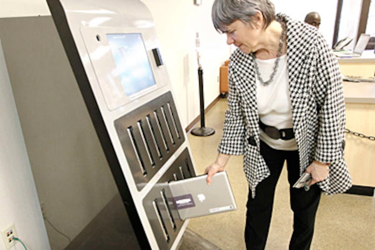 Danuta A. Nitecki, Drexel's dean of libraries, checks out a MacBook at the Hagerty Library.