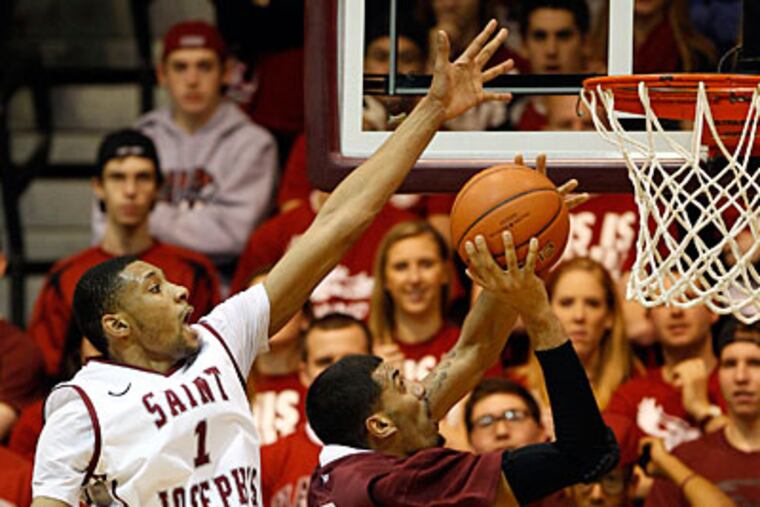 C.J. Aiken goes for the block as Fordham's Chris Gaston attempts a layup. (Yong Kim/Staff Photographer)